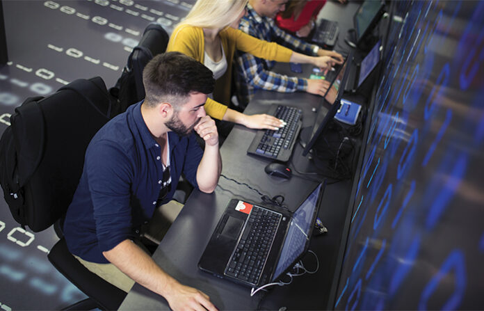 Arieal view of people working on laptops, AI disruptions