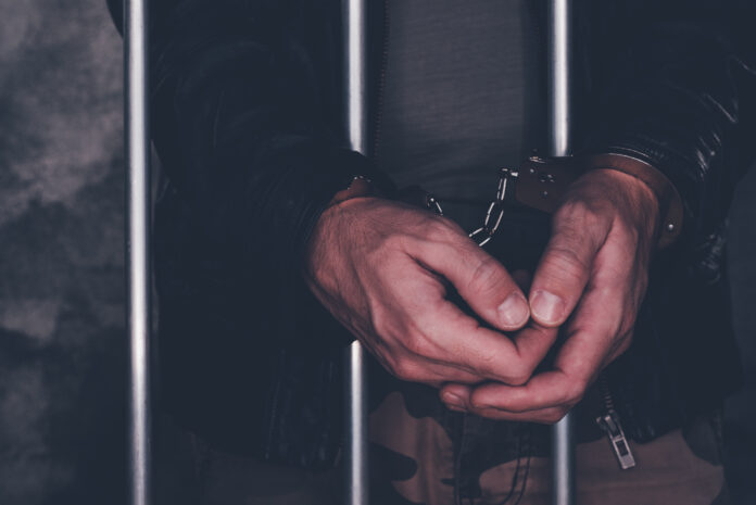 handcuffed man behind prison bars suspected undocumented immigrants