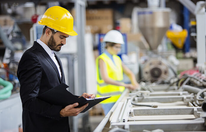 Young quality inspector checking production line OSHA inspections