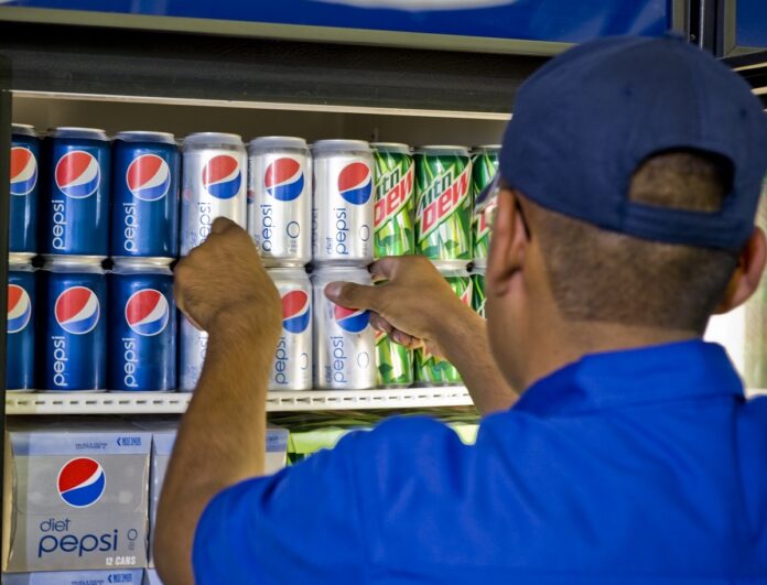 Pepsi employee stocks a cooler with Pepsi, Diet Pepsi and Mountain Dew